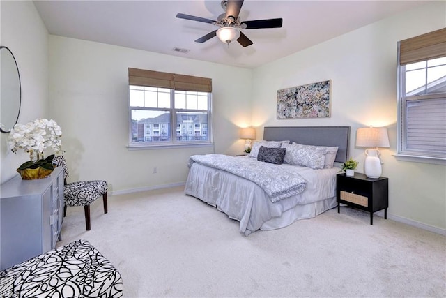 bedroom featuring visible vents, light carpet, and baseboards