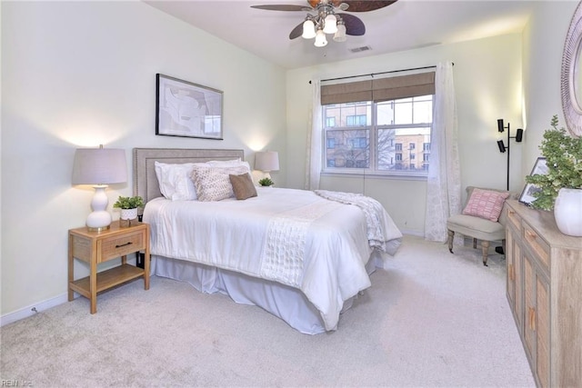 bedroom with baseboards, visible vents, and light colored carpet