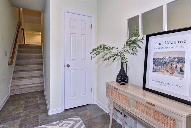 interior space with stone finish flooring, stairway, and baseboards