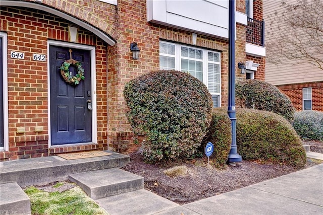 entrance to property featuring brick siding