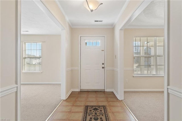 carpeted entryway featuring ornamental molding