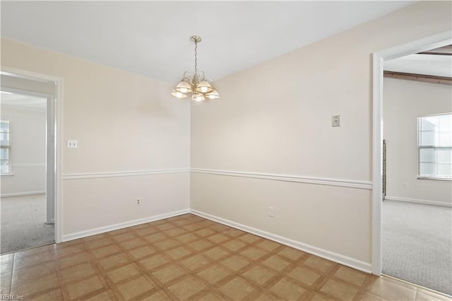 empty room with an inviting chandelier and carpet floors