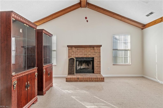 unfurnished living room with a textured ceiling, vaulted ceiling with beams, a brick fireplace, and light colored carpet