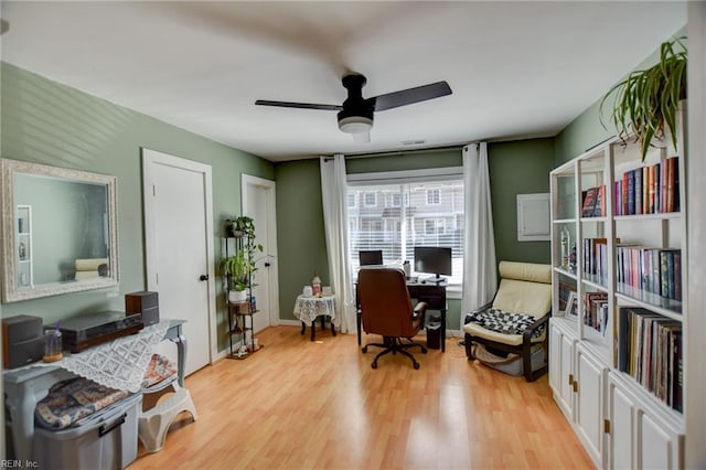 office space featuring baseboards, ceiling fan, and light wood-style floors