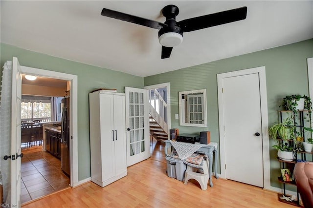 home office with ceiling fan and light wood-style flooring