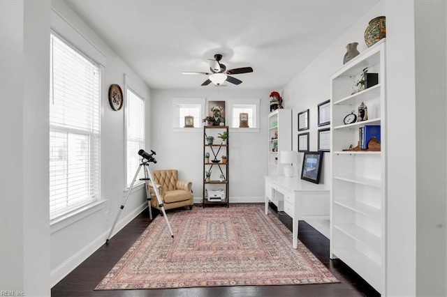 sitting room featuring a ceiling fan, baseboards, and dark wood-style flooring