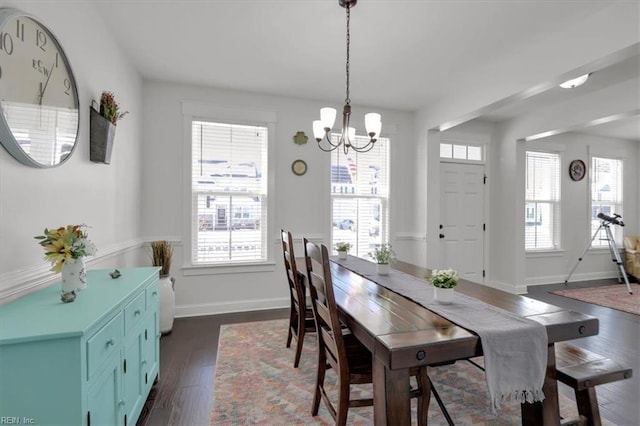 dining space with a notable chandelier, dark wood-style flooring, and baseboards