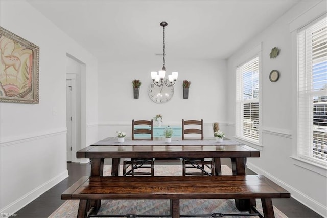 dining area with baseboards, dark wood-style flooring, and a notable chandelier