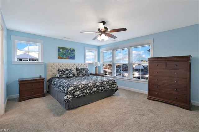 bedroom with light carpet, a ceiling fan, and baseboards