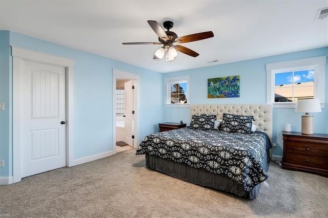 bedroom with light carpet, connected bathroom, visible vents, and baseboards