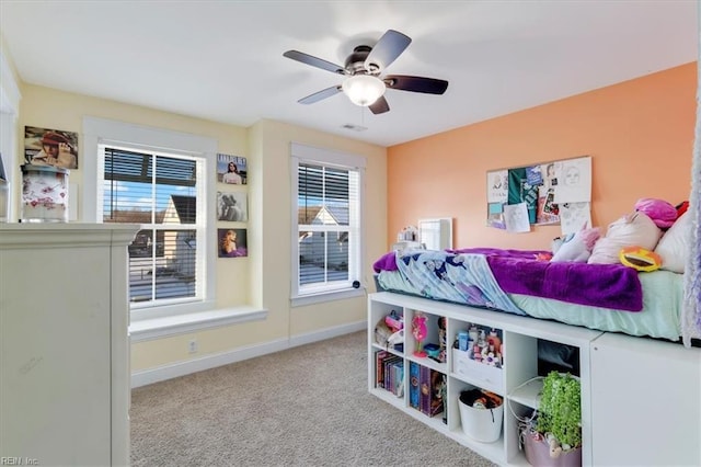 bedroom featuring ceiling fan, multiple windows, baseboards, and light colored carpet