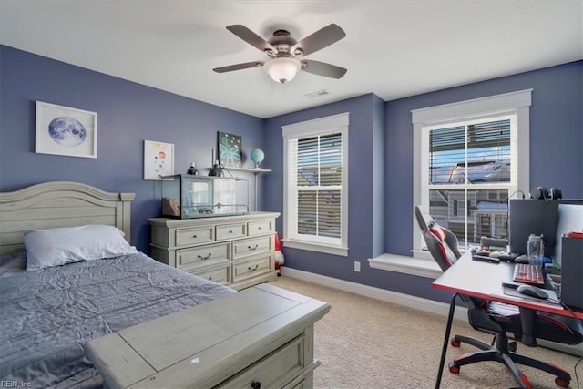 bedroom with light carpet, ceiling fan, visible vents, and baseboards