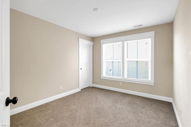 unfurnished room featuring carpet floors, visible vents, and baseboards