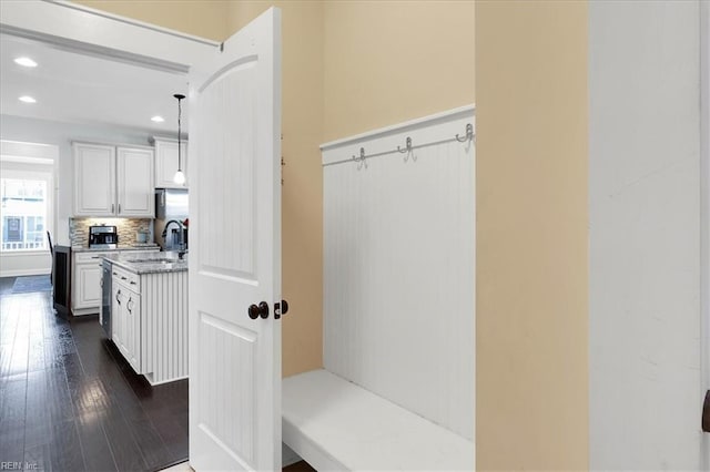 mudroom with dark wood-type flooring, a sink, and recessed lighting