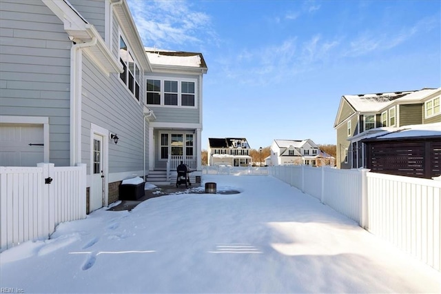 snowy yard featuring fence private yard and a residential view