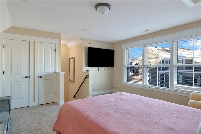 bedroom featuring baseboards, visible vents, and light colored carpet