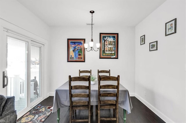 dining room with dark wood-style floors, an inviting chandelier, and baseboards