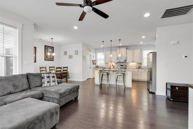 living room featuring baseboards, visible vents, dark wood-type flooring, and recessed lighting