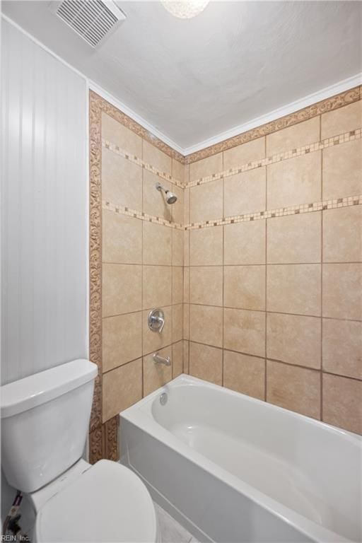 bathroom featuring tiled shower / bath combo and toilet