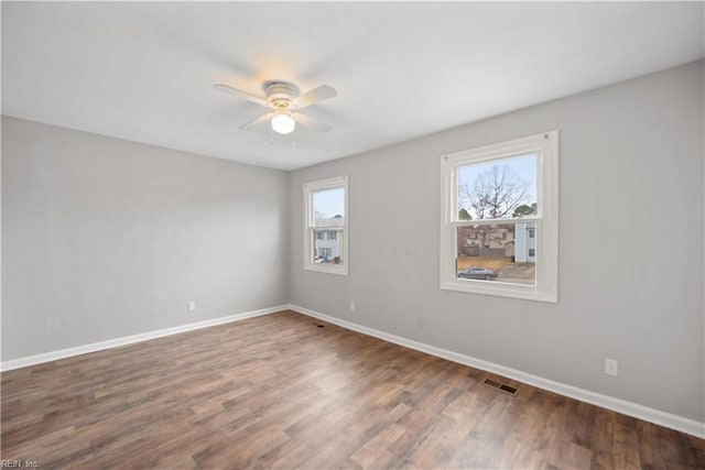 empty room with ceiling fan and dark wood-type flooring