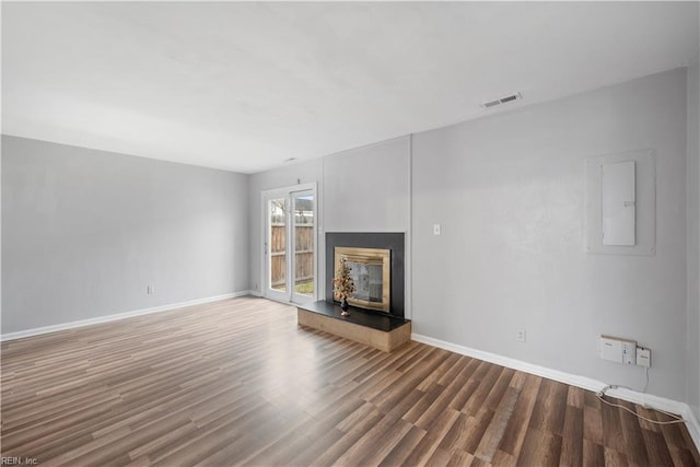 unfurnished living room with hardwood / wood-style flooring and electric panel