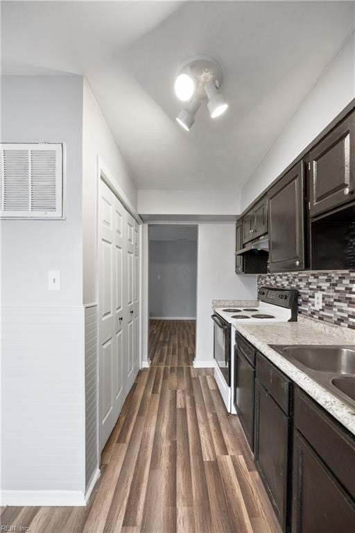 kitchen featuring electric range, dark brown cabinetry, tasteful backsplash, dishwasher, and dark wood-type flooring