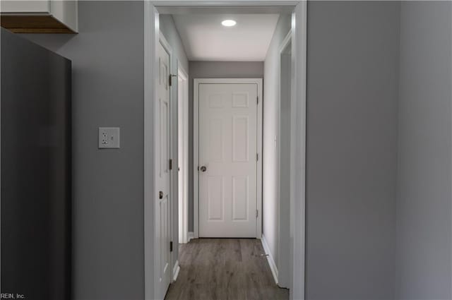 hallway with light wood finished floors and baseboards