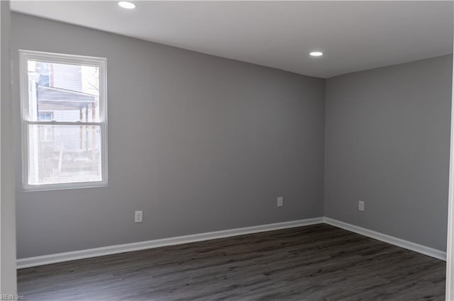 spare room featuring baseboards, dark wood-type flooring, and recessed lighting