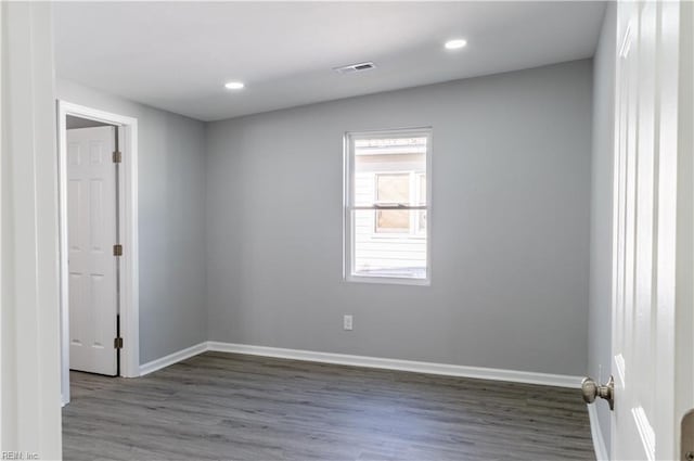 spare room with recessed lighting, wood finished floors, visible vents, and baseboards