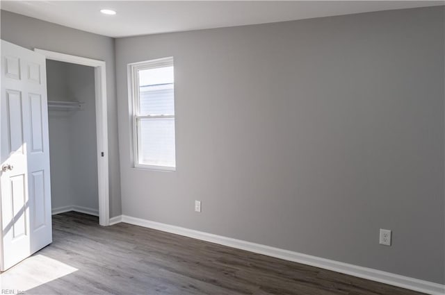 unfurnished bedroom with a closet, baseboards, multiple windows, and light wood finished floors