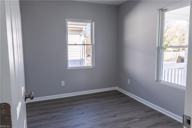 empty room with dark wood-style floors and baseboards