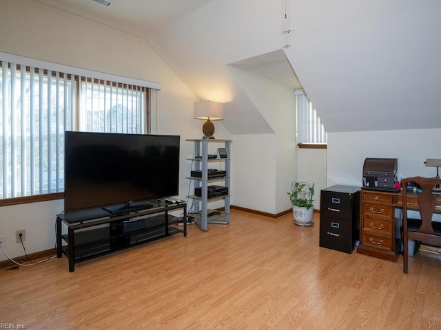 home office featuring lofted ceiling, light wood-style flooring, and baseboards