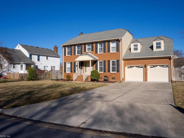 colonial-style house featuring an attached garage, brick siding, fence, driveway, and crawl space