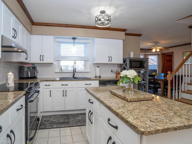 kitchen featuring black microwave, under cabinet range hood, a sink, stainless steel range with electric cooktop, and white cabinets