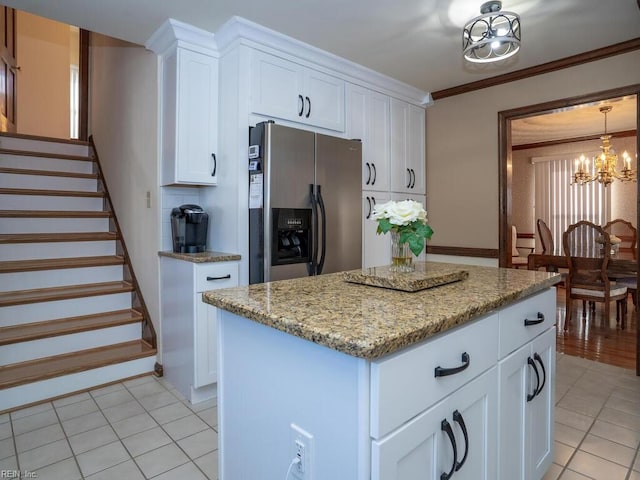 kitchen featuring stainless steel fridge with ice dispenser, a center island, an inviting chandelier, crown molding, and white cabinetry