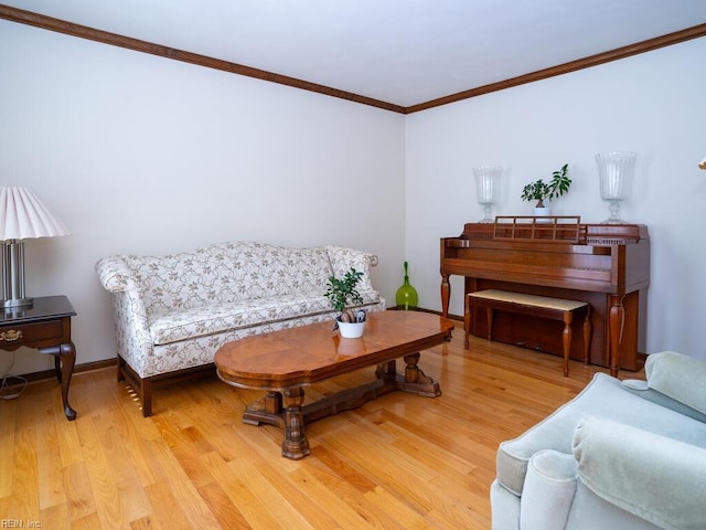 living room featuring light wood-style flooring, ornamental molding, and baseboards