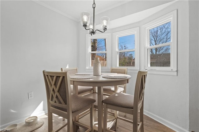 dining area with a notable chandelier, ornamental molding, and hardwood / wood-style floors