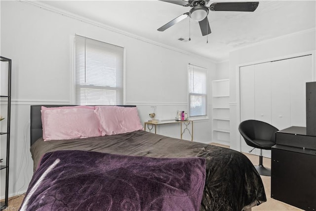 carpeted bedroom featuring a closet, crown molding, and ceiling fan