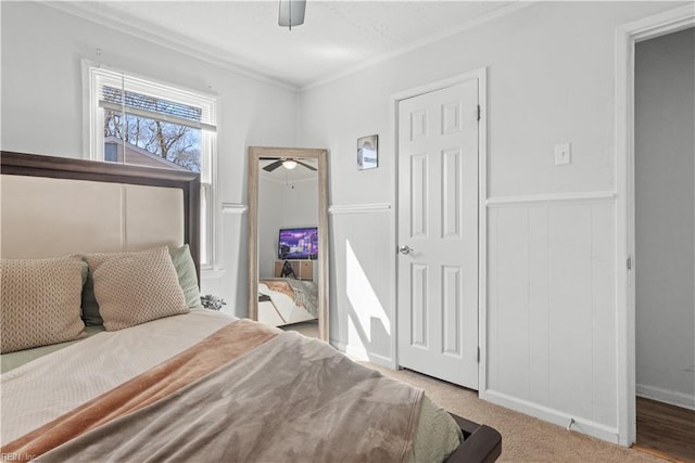 bedroom featuring ceiling fan, crown molding, and light carpet