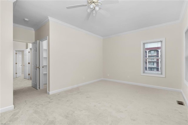 carpeted spare room with crown molding and ceiling fan