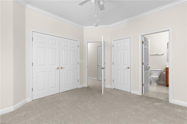 unfurnished bedroom with ceiling fan, ornamental molding, light colored carpet, and ensuite bathroom