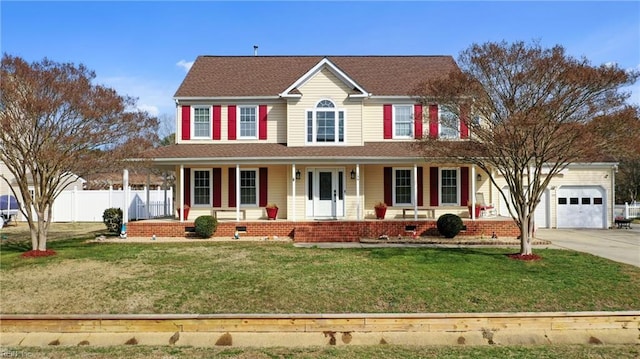 colonial-style house featuring a front lawn, a porch, and a garage