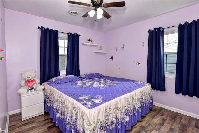 bedroom with a ceiling fan, dark wood-style flooring, visible vents, and baseboards