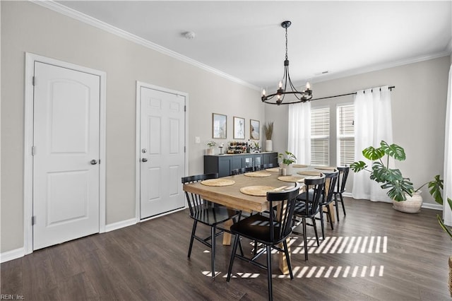 dining room featuring dark wood-type flooring, a chandelier, crown molding, and baseboards