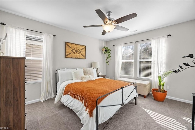 carpeted bedroom with a ceiling fan, visible vents, and baseboards