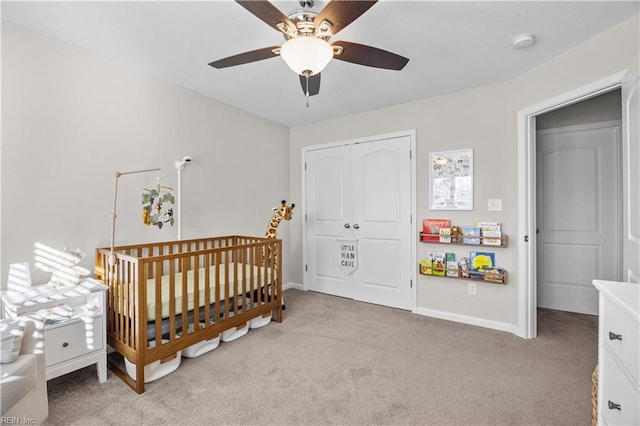 bedroom with light carpet, a closet, a ceiling fan, and baseboards