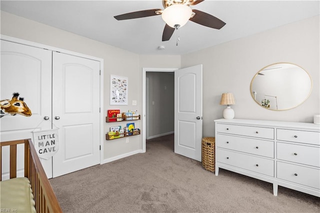 bedroom with light carpet, a closet, baseboards, and a ceiling fan