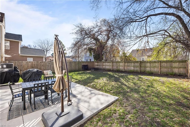 view of yard featuring a patio, outdoor dining area, and a fenced backyard