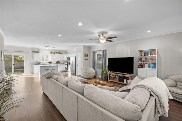 living room with crown molding, recessed lighting, and dark wood finished floors