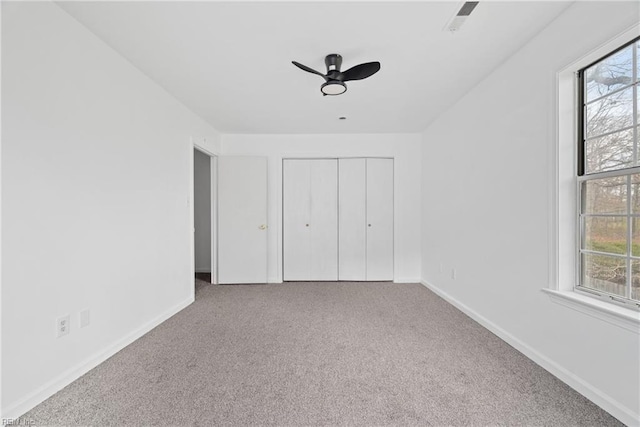 unfurnished bedroom with carpet, baseboards, and multiple windows